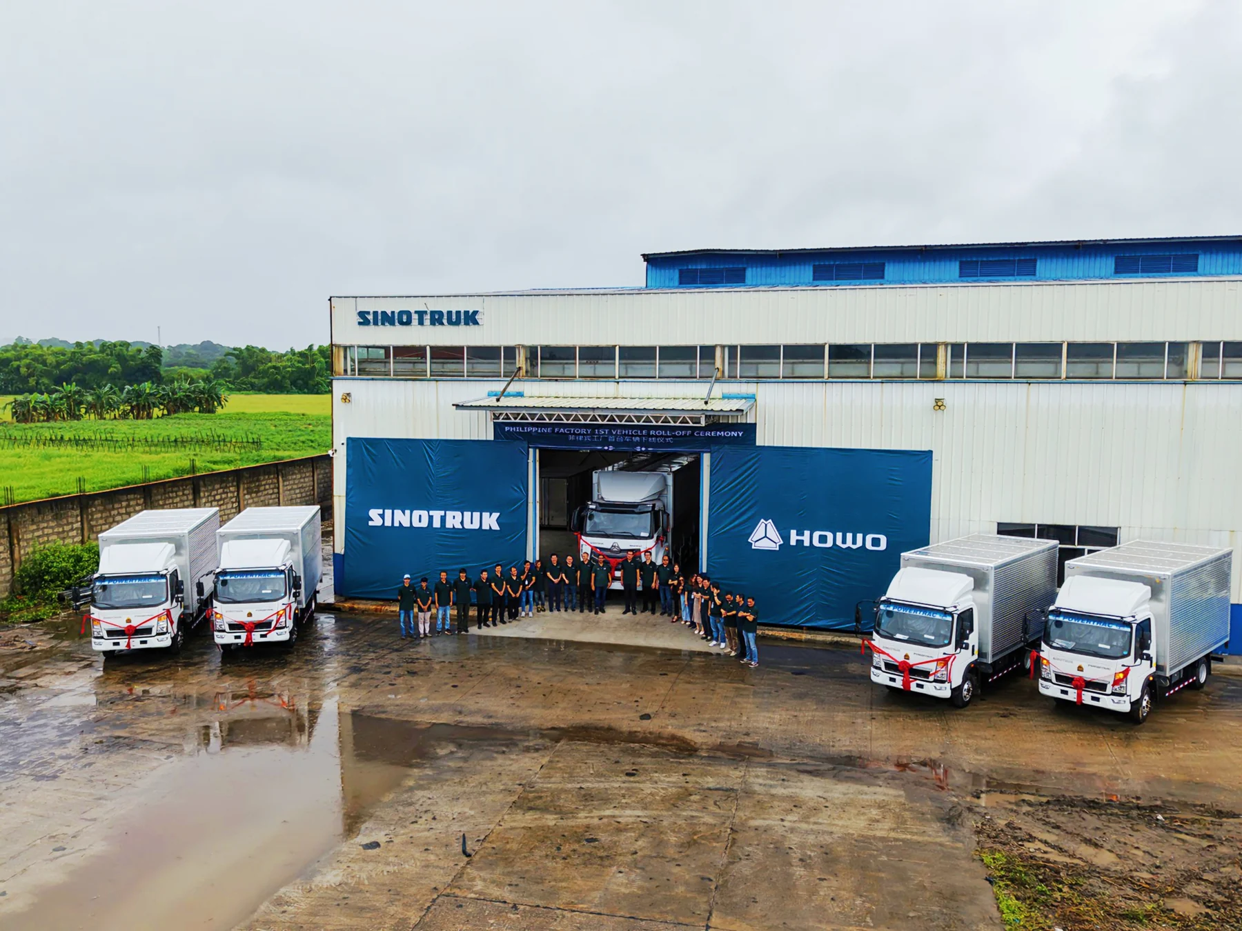 SINOTRUK facility with trucks and staff outside